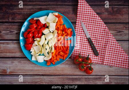 Verdure appena tagliate (pomodori, finocchio e peperone) su un rustico tavolo di legno. Preparazione per una cucina casalinga sana. Foto Stock