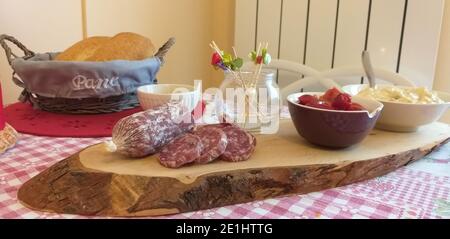 Tagliere in legno con antipasti freschi, salumi, insalata russa e peperoni alla griglia. Foto Stock