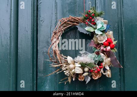 Italia, Lombardia, corona di Natale su una porta verde Foto Stock