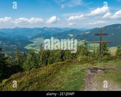 Doppia croce in legno con vista sul villaggio Liptovska Luzna al crinale dei Monti bassi Tatra con montagne, colline, prati e alberi. Slovacchia, estate Foto Stock