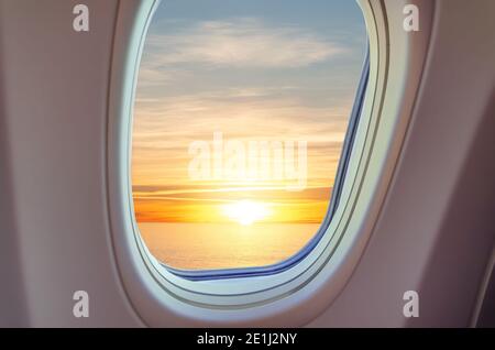 Splendida vista del tramonto dalla finestra dell'aereo in classe business. Vista all'esterno dell'oblò piano. Foto Stock