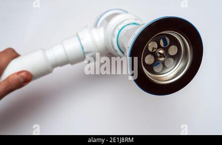 Sifone per lavabo. Sifone assemblato in plastica bianca, per il lavello tiene in mano. Foto Stock
