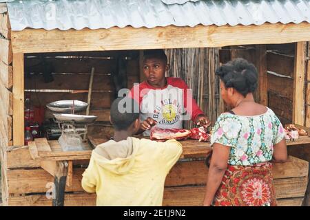 Ranohira, Madagascar - 29 aprile 2019: Donna e ragazzo malgascio sconosciuto che acquista carne cruda dal venditore al chiosco di strada. Cibo è comprato solitamente sulla strada, Foto Stock