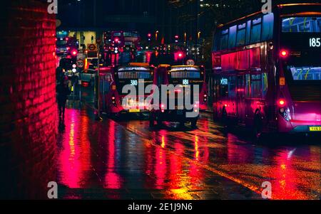 Londra, Regno Unito - 01 febbraio 2019: Autobus e taxi bloccati nel traffico pesante in una serata piovosa vicino alla stazione di Lewisham, luci rosse luminose riflettono Foto Stock