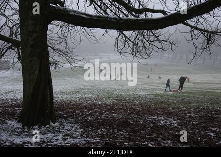 Glasgow, Regno Unito, 7 gennaio 2021. La gente gode dell'aria fresca, della neve leggera e delle condizioni nebbiose, una fuga dal blocco, con un viaggio al Queen's Park nel sud della città. Photo credit: Jeremy Sutton-Hibbert/Alamy Live News Foto Stock