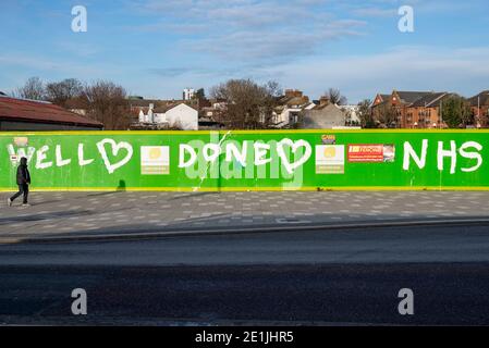 Southend on Sea, Essex, Regno Unito. 7 gennaio 2021. Dopo aver affrontato le critiche per l'affollato lungomare Southend Borough Council ha chiuso il parcheggio per auto fronte mare per scoraggiare i visitatori durante COVID 19. La mattina è scoppiata in un pomeriggio di sole che attrae alcune persone fuori per l'esercizio ma non in gran numero. Una persona che cammina oltre il sito di costruzione ritardato con messaggio di ringraziamento per NHS Foto Stock