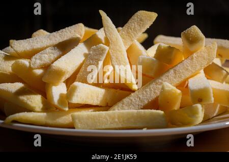 Patatine fritte surgelate su un piatto su uno sfondo di legno. Prodotto  semilavorato di patate congelate Foto stock - Alamy