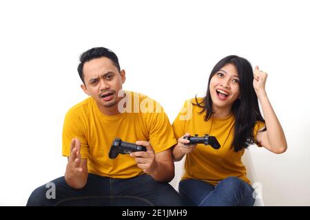 Coppia asiatica che gioca a videogiochi. Persone asiatiche che detengono controller di videogiochi. Isolato su sfondo bianco con copyspace Foto Stock