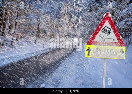 in inverno, la segnaletica stradale segnala la presenza di ghiaccio e neve Foto Stock