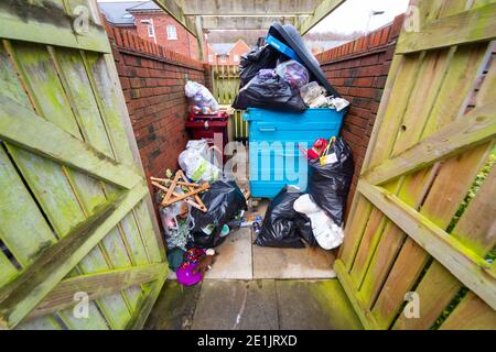 Contenitori pieni e traboccanti, wastbin, trashcan, ricettacolo, rifiuti in un deposito di bidoni residenziale su una tenuta di alloggi del Regno Unito, Inghilterra, Regno Unito. Rifiuti, rifiuti Foto Stock