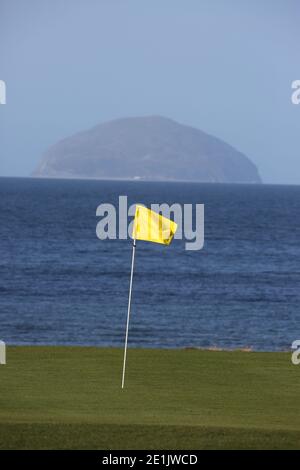 Campo da golf municipale di Girvan, Ayrshire, Scozia, Regno Unito. Segnaposto giallo che segna il foro, Ailsa Craig sullo sfondo Foto Stock