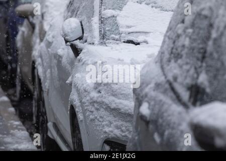 Madrid, Spagna - 07 gennaio 2021: Auto parcheggiate in una strada di Madrid, coperta di neve, da un'ondata di freddo polare, nel mezzo della bizzarda e della neve. Foto Stock