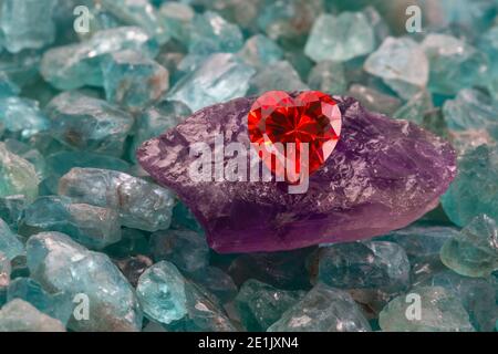 Diamante giallo a forma di cuore su pietra viola grezza ametista in il  mezzo delle gemme azzurre del cielo grezze Foto stock - Alamy