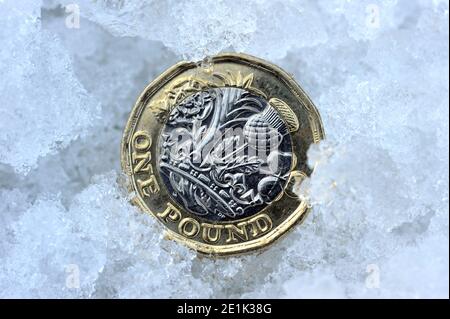BRITISH UNA LIBBRA MONETA IN NEVE E GHIACCIO RE ECONOMIA SALARI REDDITI PENSIONI INVERNO ECC REGNO UNITO Foto Stock