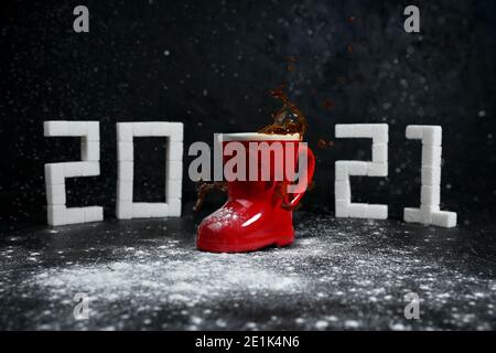 Anno nuovo 2021. Spruzzi di caffè e neve nei prossimi 2021. Cifre da zucchero. Foto Stock