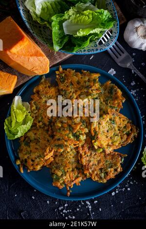 Tortino vegetale con zucca, cipolla e aneto. Frittelle di zucca su sfondo nero. Foto Stock