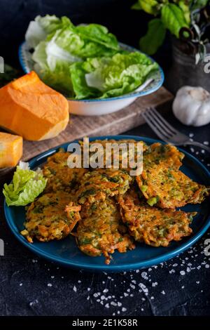 Tortino vegetale con zucca, cipolla e aneto. Frittelle di zucca su sfondo nero. Foto Stock