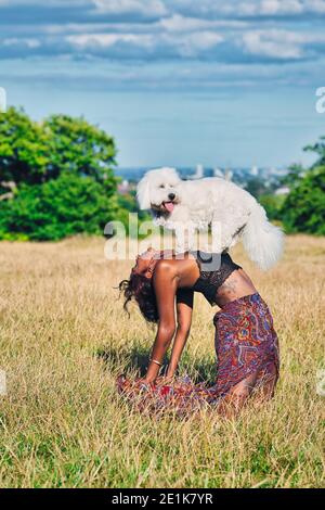 Donna che fa yoga con il suo cane .Doga yoga con il vostro cane. Foto Stock