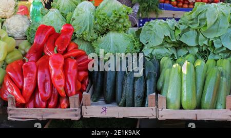 Verdure biologiche fresche disposte in fila in bancarella di mercato casse Foto Stock