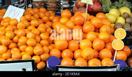 Grande pila di arance e tangerini venduti sul mercato all'aperto stallo Foto Stock