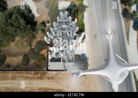 Drone velivolo senza equipaggio che volano vicino e la torre delle cellule di ispezione. Foto Stock