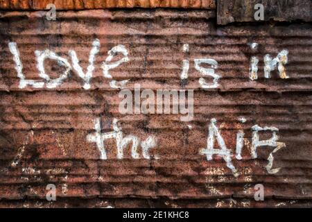 porta in ferro corrugato arrugginita con un messaggio scritto di amore è nell'aria Foto Stock