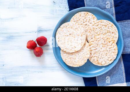 cracker di riso, frutti di bosco su tavola blu, cibo super Foto Stock