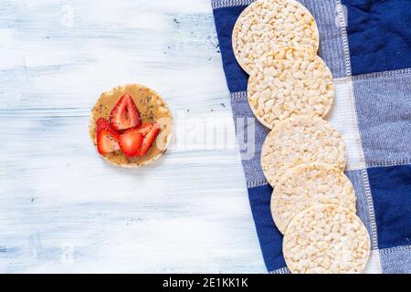 cracker di riso, frutti di bosco su tavola blu, cibo super Foto Stock