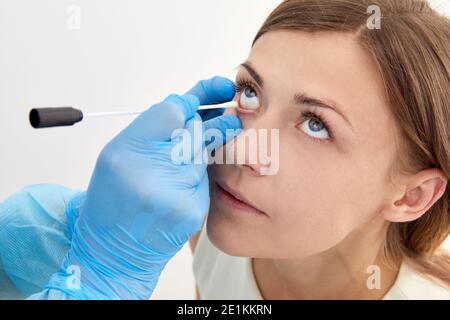 Medico che preleva il campione con il tampone dall'occhio Foto Stock