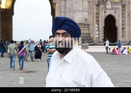 Ritratto dell'uomo indiano sikh con barba boscata di fronte al Gateway of India Mumbai. Foto Stock