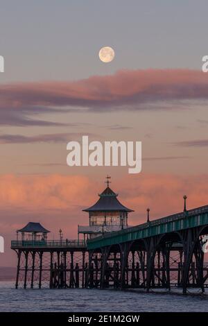 La luna si tramonta dietro il molo di Clevedon nel Somerset. Foto Stock