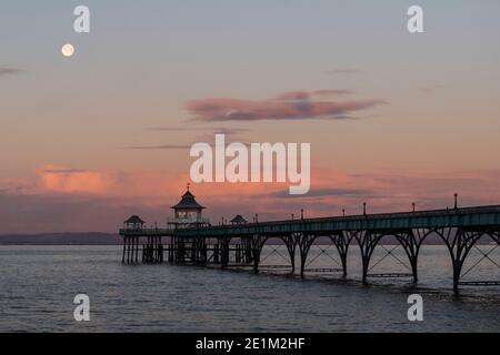 La luna si tramonta dietro il molo di Clevedon nel Somerset. Foto Stock