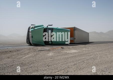 Il camion a 18 ruote rovesciato dalla forza dell'uragano si avvolge in tempesta di polvere sulla strada vicino a Tonopah, Nevada, USA Foto Stock