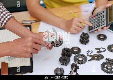 Ingegnere discutendo e progettazione circa la marcia meccanica parti in ufficio. Foto Stock