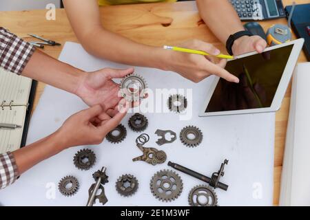 Ingegnere discutendo e progettazione circa la marcia meccanica parti in ufficio. Foto Stock