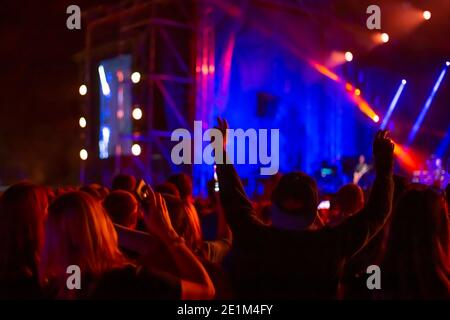 la folla dei fan alza le mani e balla in un night club, un concerto e illuminazione luminosa, tempo libero e di intrattenimento, messa a fuoco morbida Foto Stock