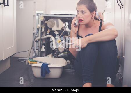 La donna ha bisogno di un idraulico per riparare la perdita Foto Stock