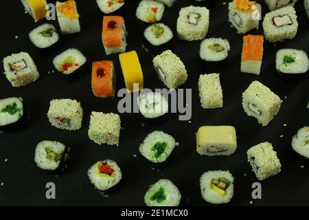 Sushi roll con salmone, tonno, avocado e cetriolo. Un sacco di rotoli. Panini sushi. Foto Stock