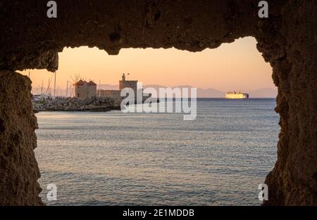 Tramonto di Rodi sulla Fortezza di San Nicola e i mulini a vento che costeggiano il porto di Mandraki, Rodi, Isola di Rodi, Grecia Foto Stock