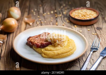 Cucina ceca, carne affumicata con porridge di piselli e cipolla fritta fino a doratura Foto Stock