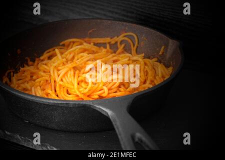 Spaghetti bolognesi cotti in una padella di ghisa. Con effetto di illuminazione Foto Stock