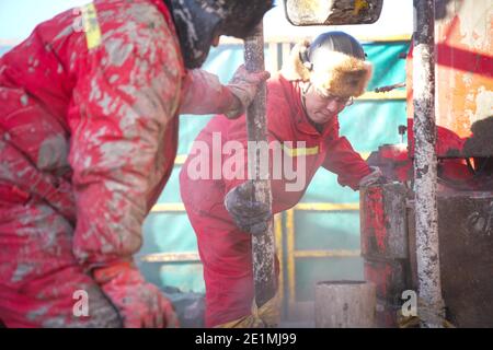 (210108) -- DAQING, 8 gennaio 2021 (Xinhua) -- lavoratori del team di perforazione n. 1205 lavorano in una piattaforma di perforazione petrolifera a Daqing Oilfield a Daqing, provincia di Heilongjiang, 7 gennaio 2021. Il team di perforazione n. 1205 di Daqing Oilfield ha perforato più di 100,000 metri accumulati nel 2020, rispettando l'obiettivo di realizzare un totale annuale di riprese perforate di oltre 100,000 metri per quattro anni consecutivi. Il team era guidato da Wang Jinxi, un operaio modello del giacimento petrolifero che dedicò la sua vita allo sviluppo dell'industria petrolifera cinese. (Xinhua/Wang Song) Foto Stock