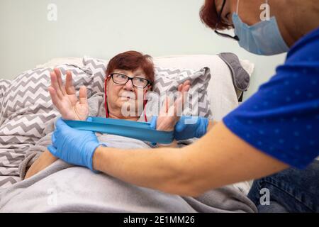 Infermiera che aiuta l'esercizio della donna anziana. La terapeuta fisica femminile aiuta la donna anziana ad esercitarsi a casa Foto Stock