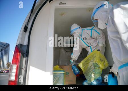 (210108) -- SHIJIAZHUANG, 8 gennaio 2021 (Xinhua) -- Mei Yiqi (L) disinfetta la scatola contenente campioni di acido nucleico in un veicolo refrigerato a Shijiazhuang, nella provincia di Hebei, nella Cina settentrionale, 8 gennaio 2021. Mei Yiqi, 30 anni, che lavora nel reparto logistico di Wuhan KingMed Diagnostics Group Co., Ltd., ha salutato la sua famiglia mercoledì e ha preso un treno ad alta velocità da Wuhan a Shijiazhuang per aiutare a combattere la pandemia COVID-19. Nel 2020, Mei ha partecipato successivamente al lavoro anti-pandemia a Wuhan e Chengdu, compresa la raccolta e il trasporto di COVID-19 t. Foto Stock