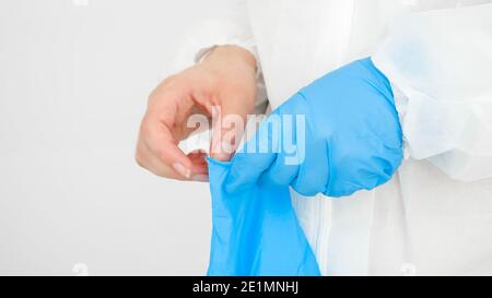 Closeup delle mani di dottore che indossano guanti di gomma protettivi. Lotta globale e protezione contro il covid-19 e il coronavirus Foto Stock