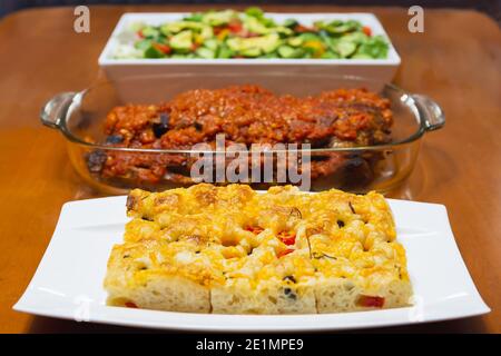 Focaccia appena fatta in casa sul tavolo da pranzo in legno. Foto Stock