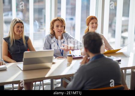 Commissione aziendale avere un colloquio in un'atmosfera piacevole con un candidato maschile per un lavoro. Persone, lavoro, azienda, business concept. Foto Stock