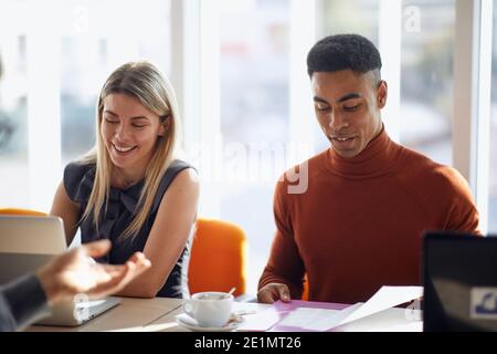 Commissione d'impresa che gode di un'intervista in un'atmosfera piacevole con un candidato per un lavoro. Persone, lavoro, azienda, business concept. Foto Stock