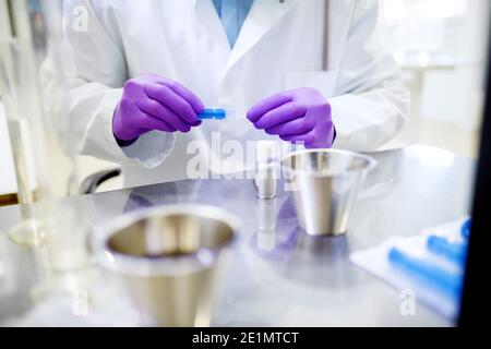 Primo piano di un mans Hands che lavora su alcuni esperimenti in laboratorio. Foto Stock