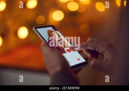 Uomo che tiene smartphone e premendo come sotto attraente giovane donna foto del profilo Foto Stock